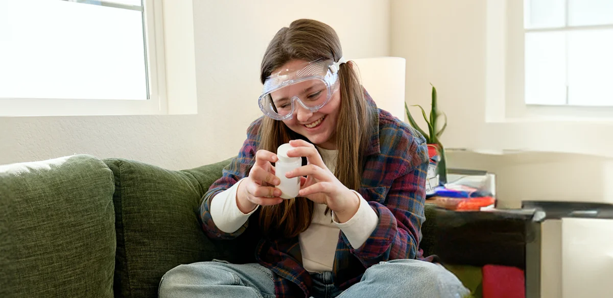 Student working on a science project wearing goggles