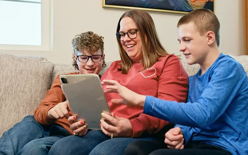 Mother with her sons working on their ipad